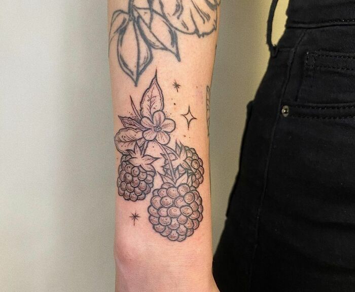 Nature tattoo with detailed blackberry design on forearm, showcasing botanical art and personal expression.