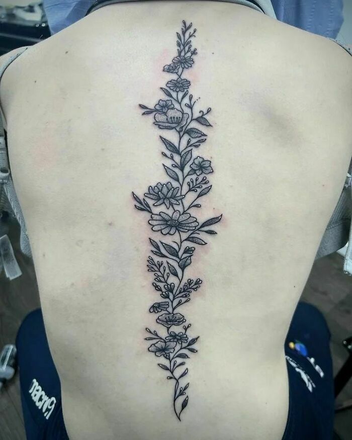 Black floral spine tattoo