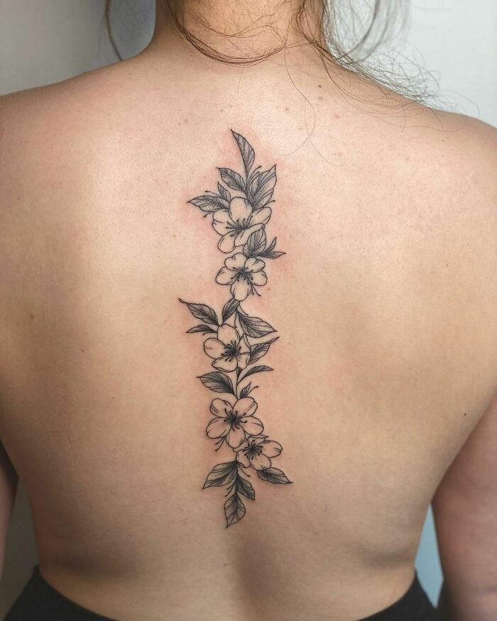 Floral spine tattoo design on a woman's back, showcasing elegance and intricate details.