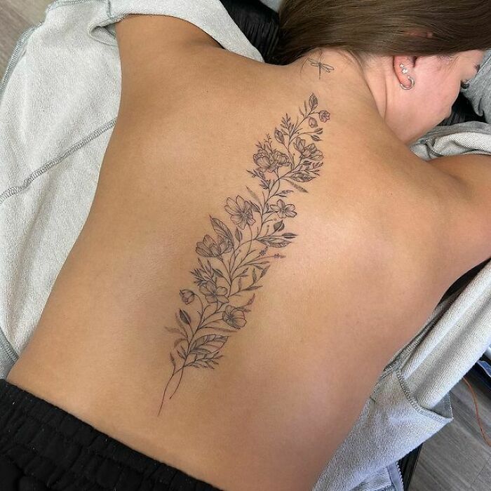 Floral spine tattoo on woman’s back
