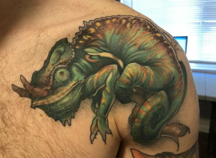 Colorful chameleon tattoo on a person's shoulder, showcasing vibrant animal tattoo design.