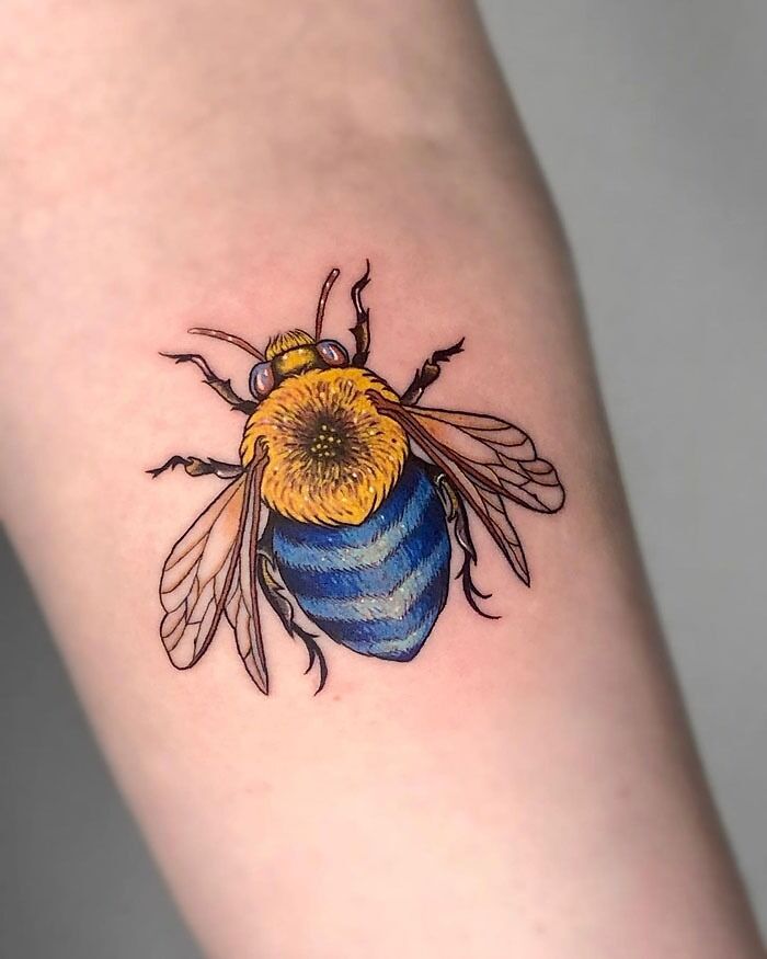 Colorful bee animal tattoo design on forearm.