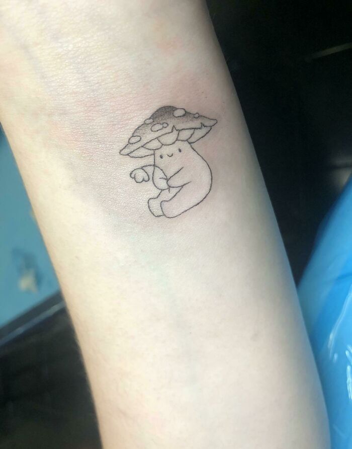 Mushroom guy tattoo on wrist