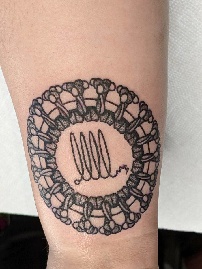 Ornate wrist tattoo design featuring intricate patterns in a circular shape.