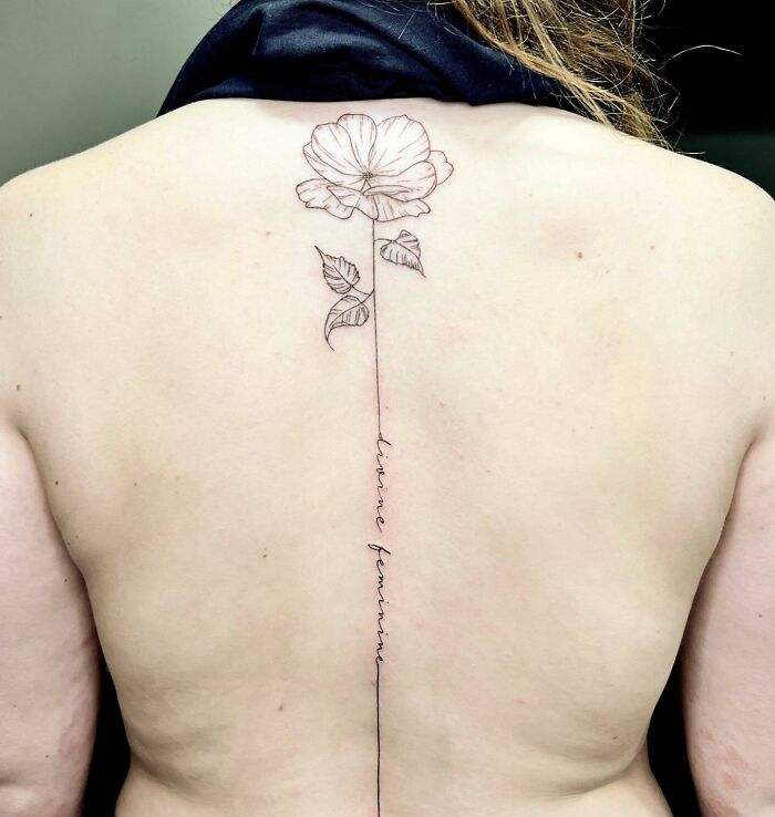 Flowers and line with text spine tattoo 