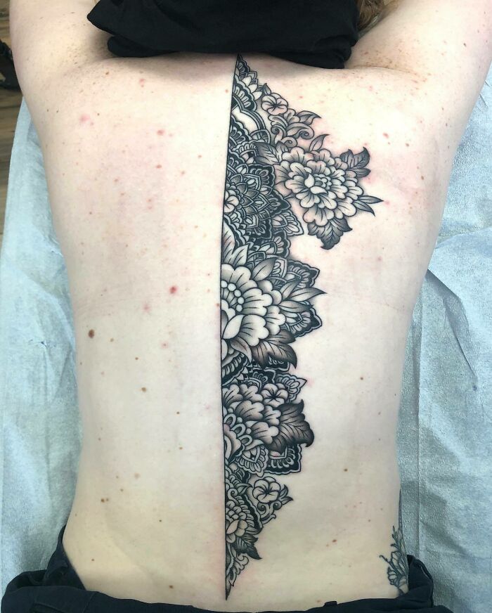 Elegant floral spine tattoo design on a person's back.