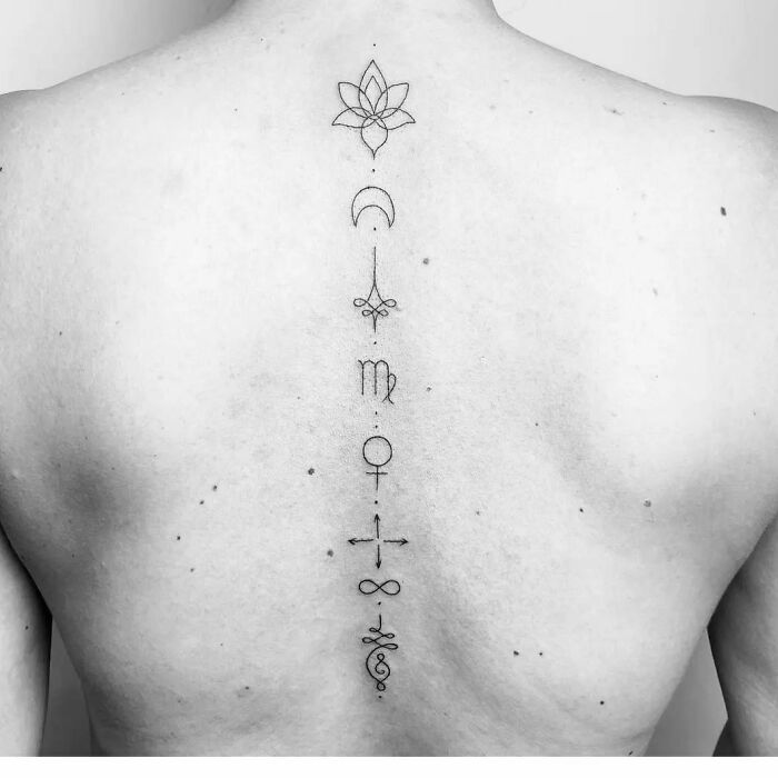 Minimal linear symbols tattoo on back