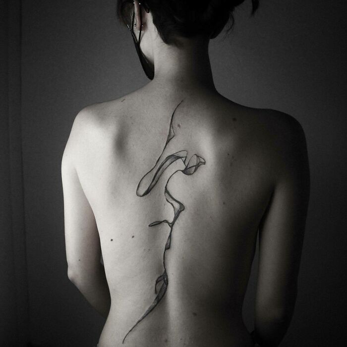 Abstract floating black lines spine tattoo 