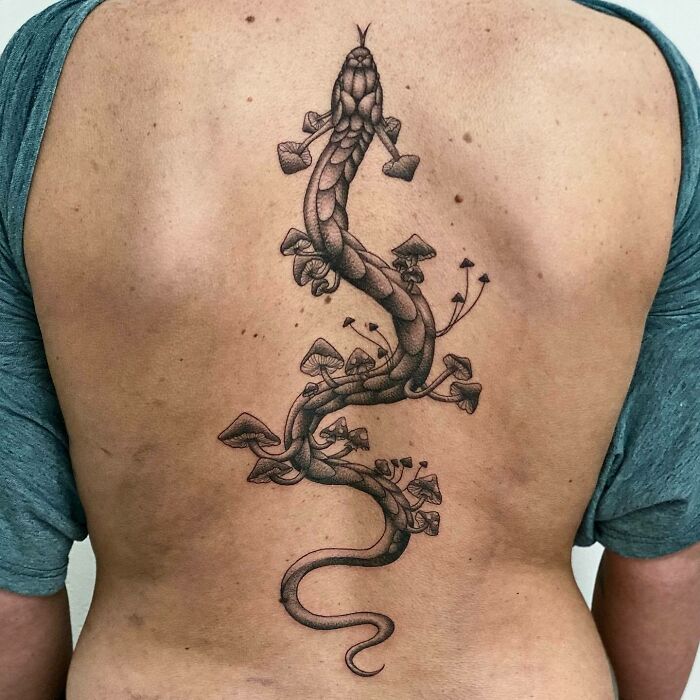 Snake with many mushrooms on it tattoo on back