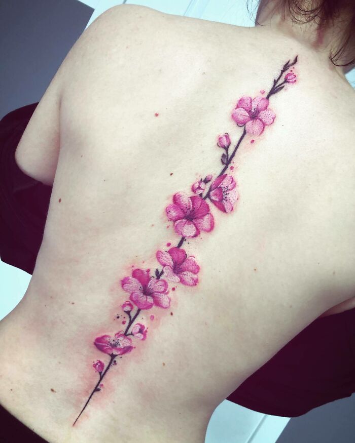 Cherry blossom branch spine tattoo
