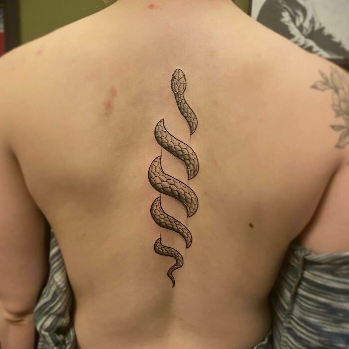 Snake around the spine tattoo