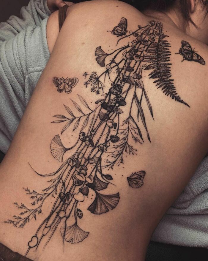 Plants and flowers along the spine tattoo 