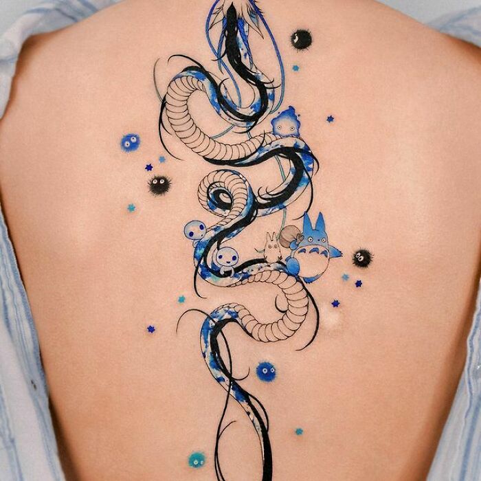Intricate spine tattoo with blue and black design, featuring mythical creatures and vibrant accents.