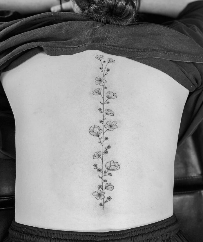 Small flowers along the spine tattoo 