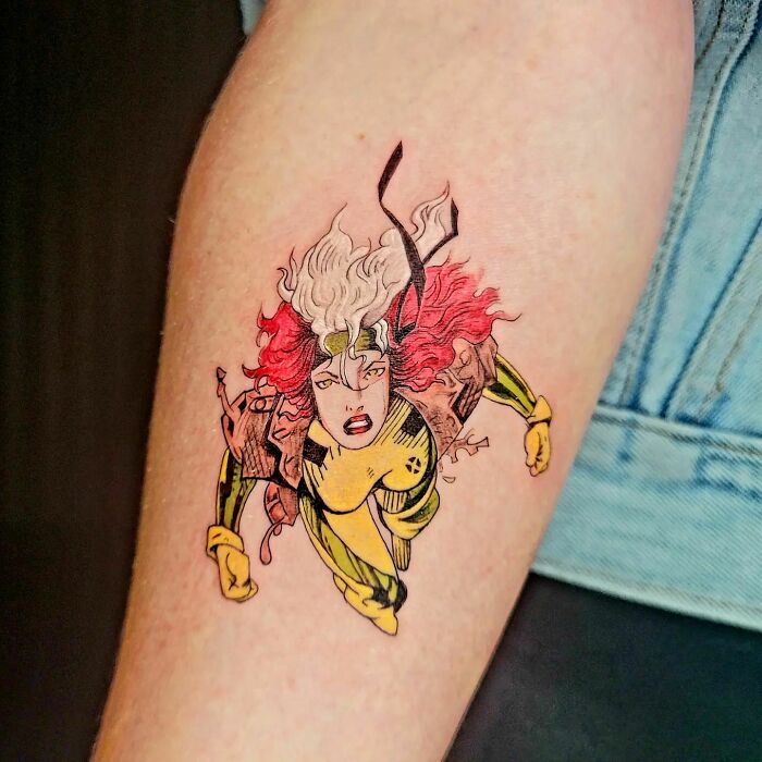 Marvel tattoo of a superhero Rouge character on a person's arm, showcasing vibrant colors and detailed artwork.