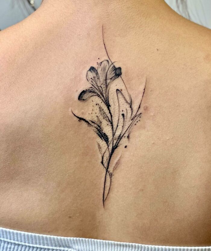 Black lily tattoo on back