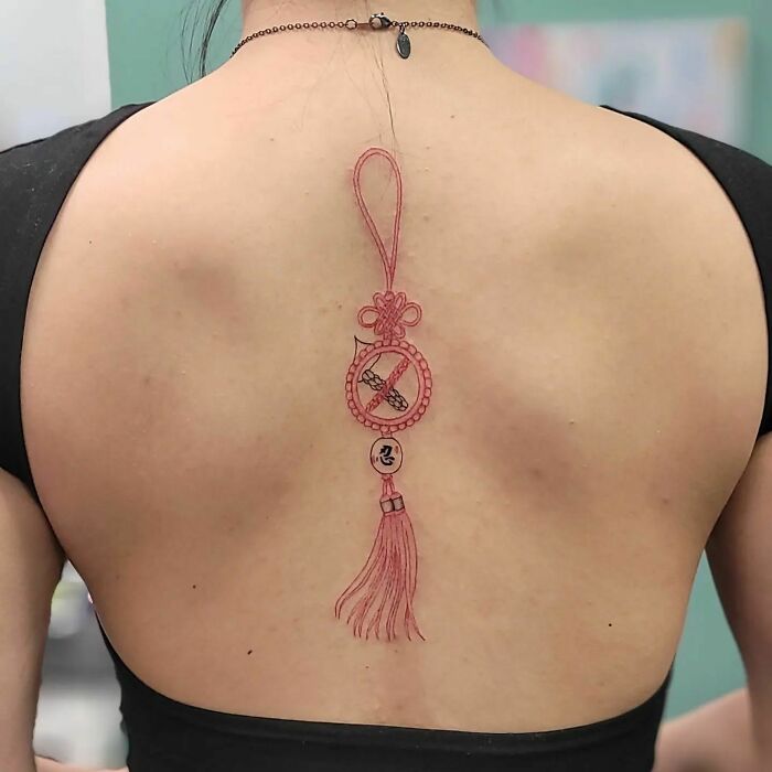 Red norigae tattoo on spine