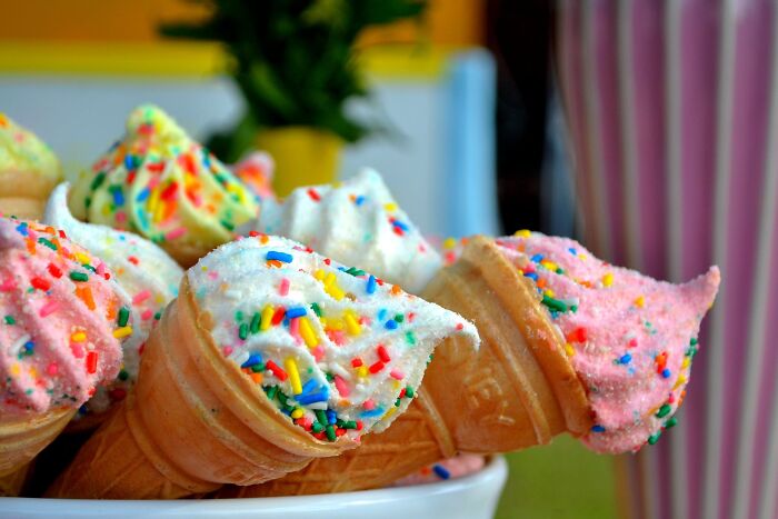 a soft-serve vanilla ice cream cone with rainbow sprinkles
