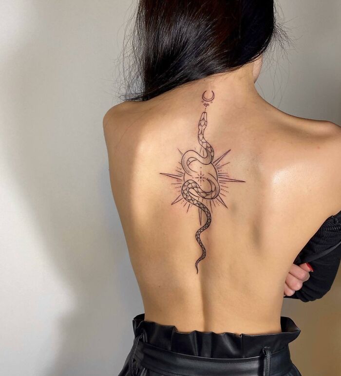 Snake, sun and small moon spine tattoo 