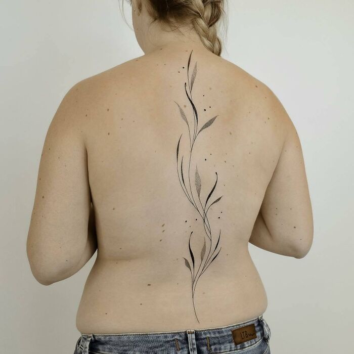 Black linear leaves tattoo on spine