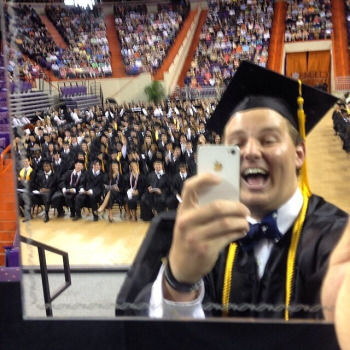 Person taking a picture of himself and other graduation students 