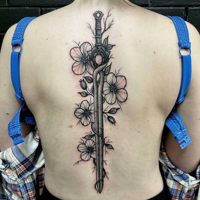 Black sword with flowers tattoo on back