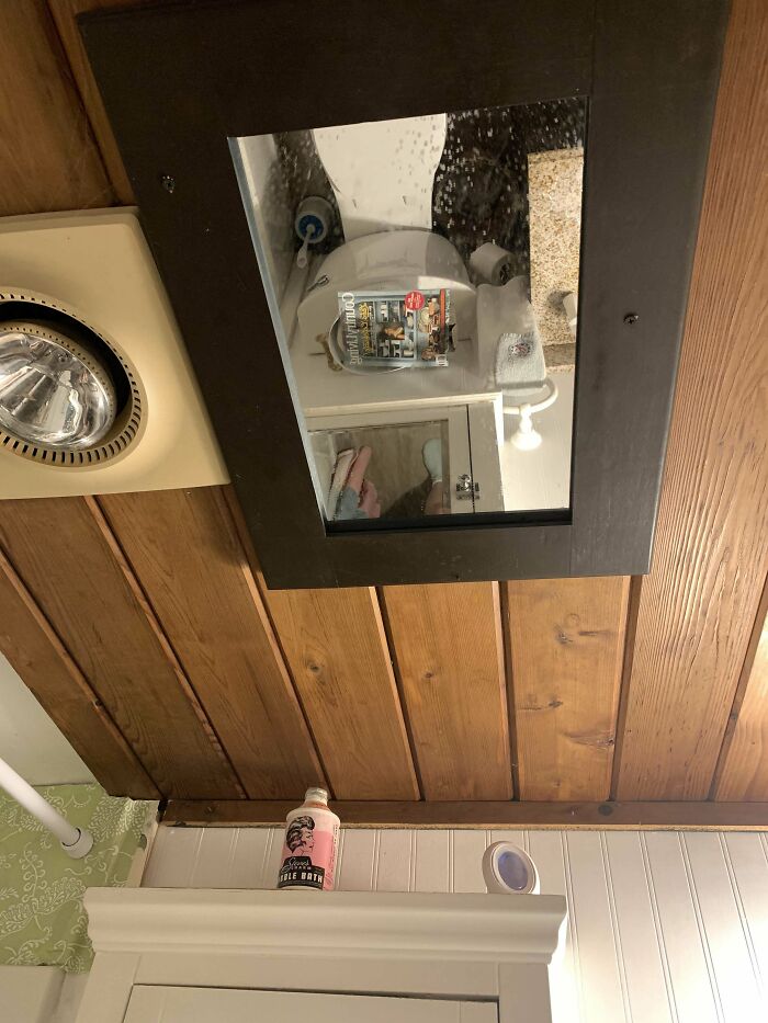 Mirror on the ceiling above a toilet seat 