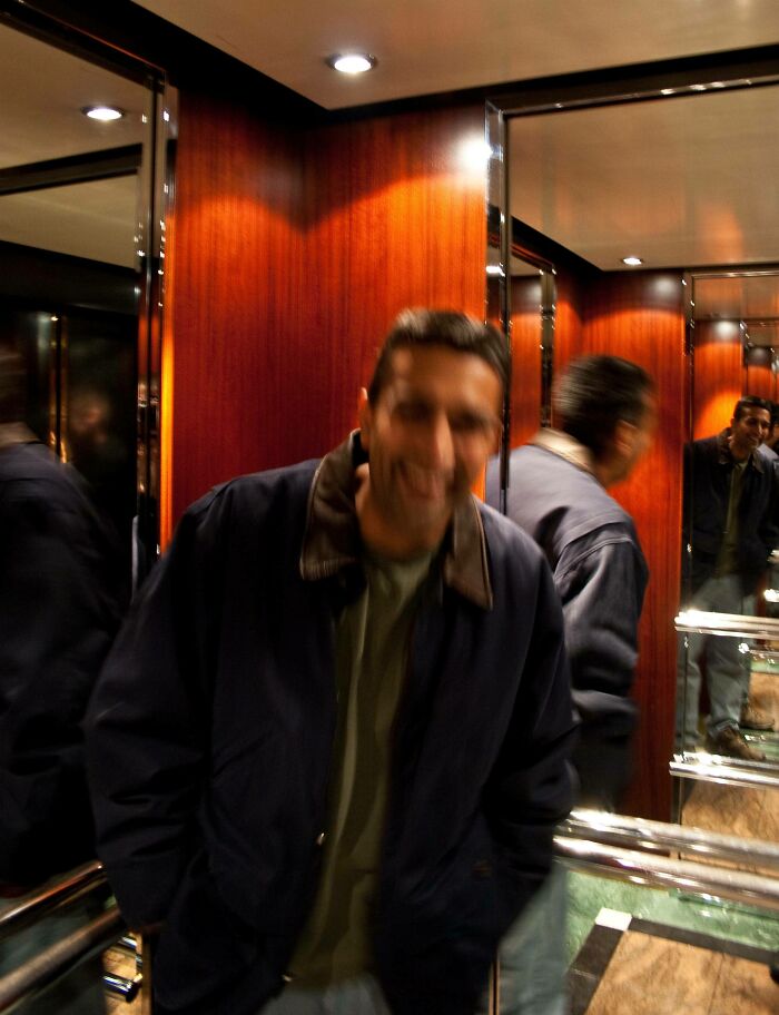 Multiple mirror reflections of a man in the lift 