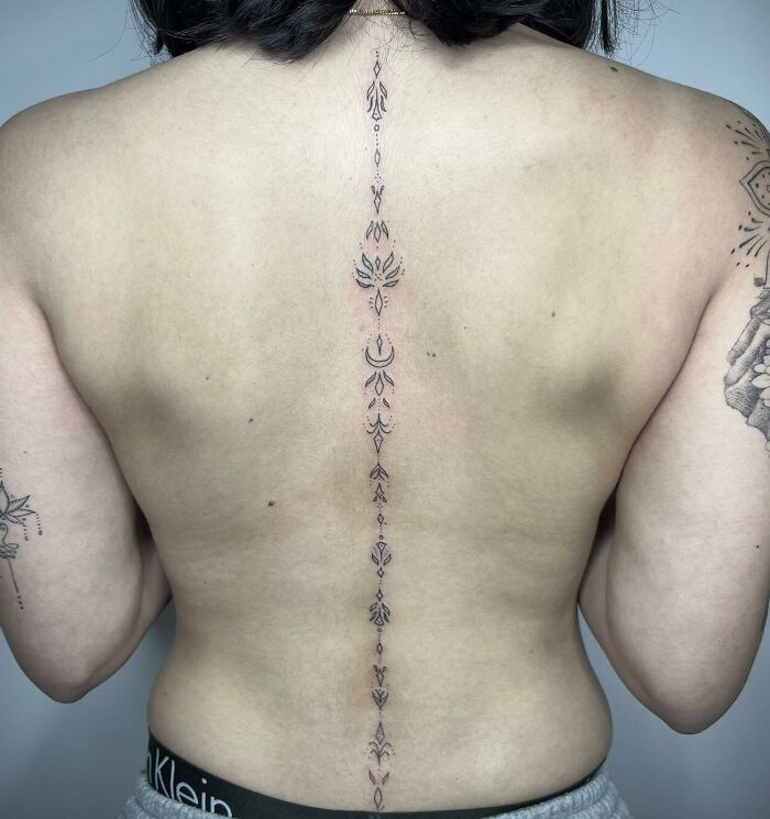 Different symbols along the spine tattoo 