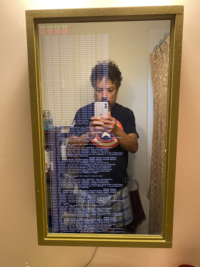 Man posing in front of a broken smart mirror 