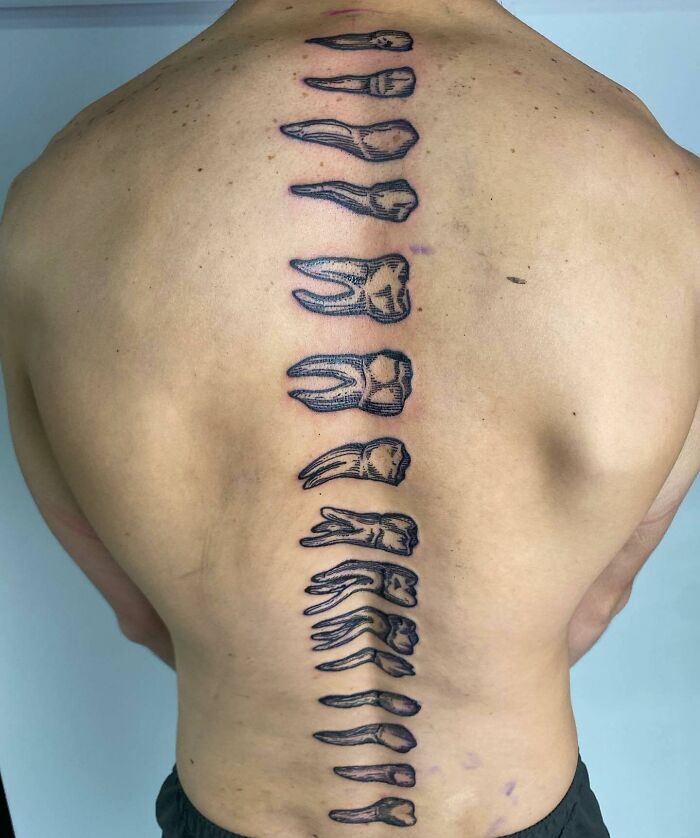 Spine tattoo featuring abstract tooth designs on a person's back.