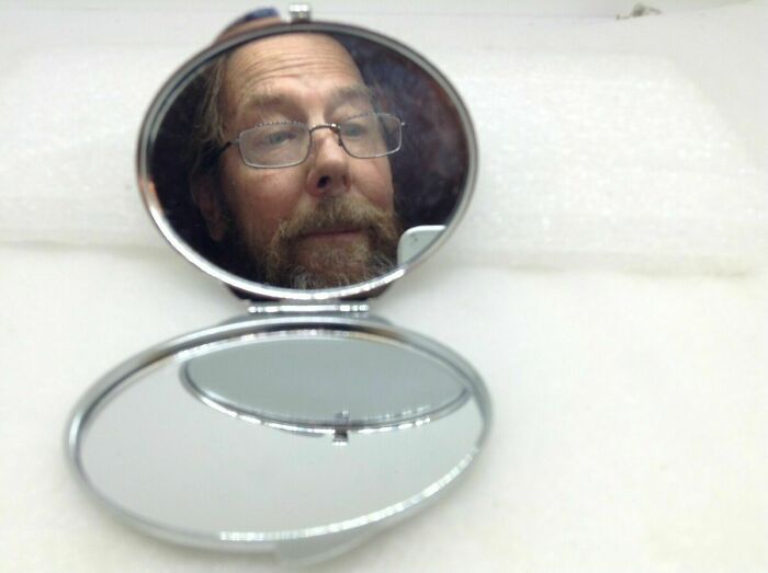 Funny man reflection in a small mirror 