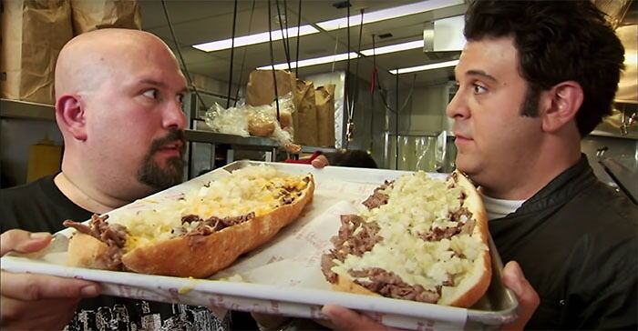 Person holding food and looking at each other in Man V. Food
