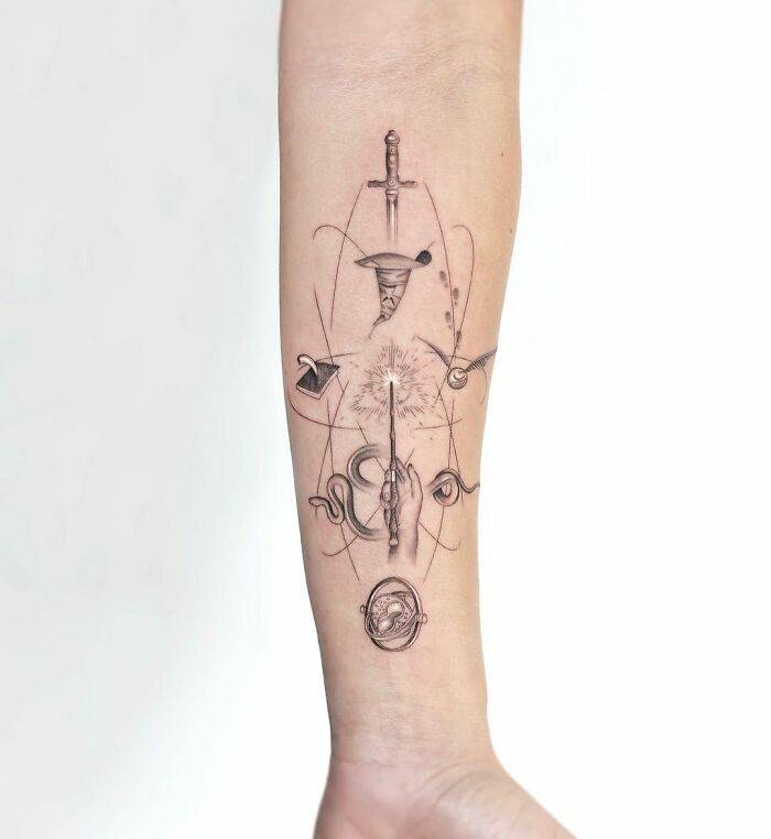 Harry Potter tattoo on forearm featuring a wand, sword, snake, and other magical elements from the Wizarding World.