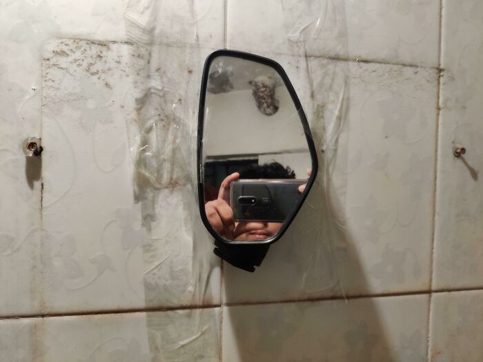 Mirror attached to wall with duct tape 