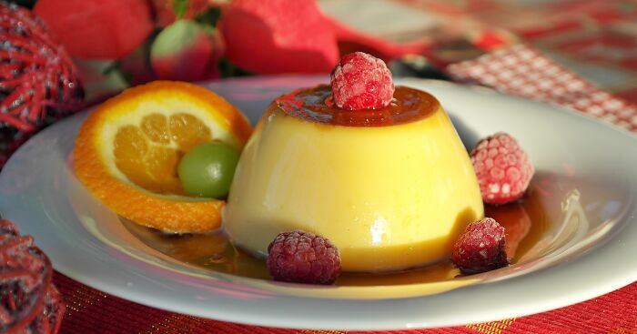 Vanilla pudding with raspberry on top of it 