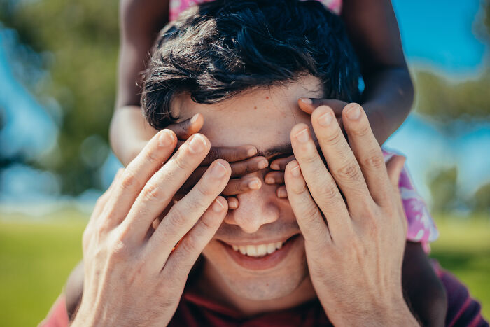 A girl covering mans eyes 