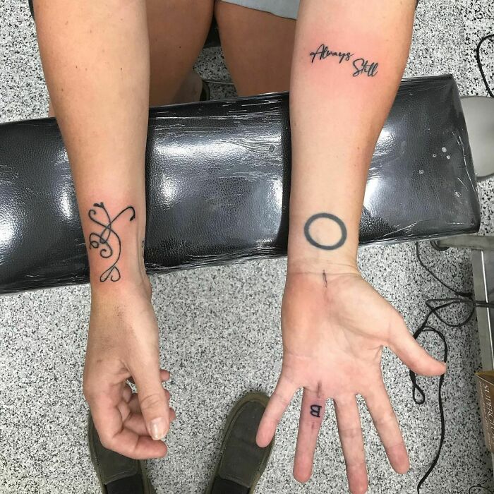 Simple signs tattoo on wrists