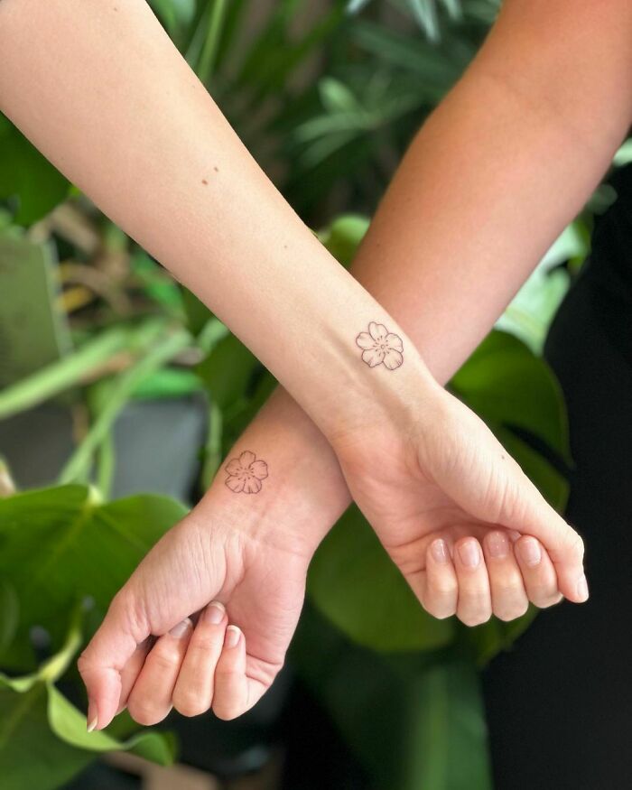 Matching floral tattoos for sisters on wrist
