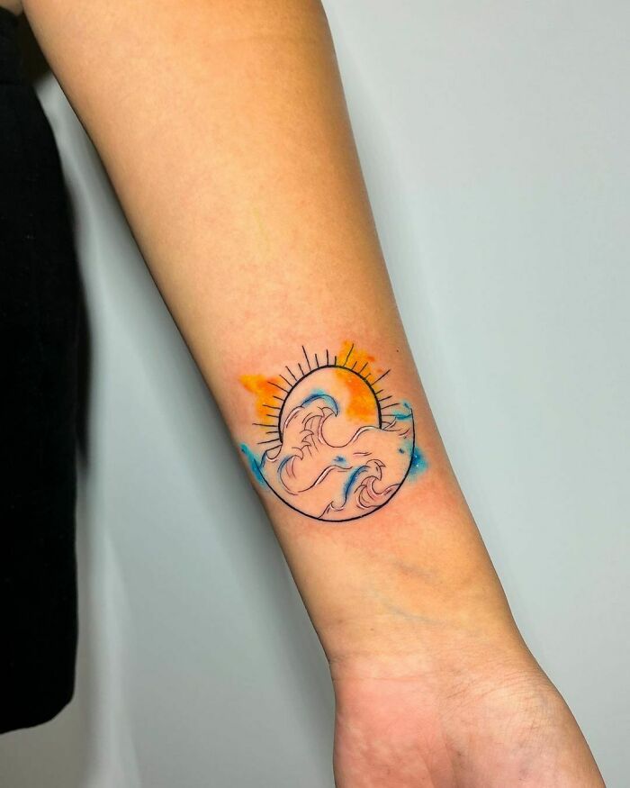 Sea and the sun on wrist tattoo