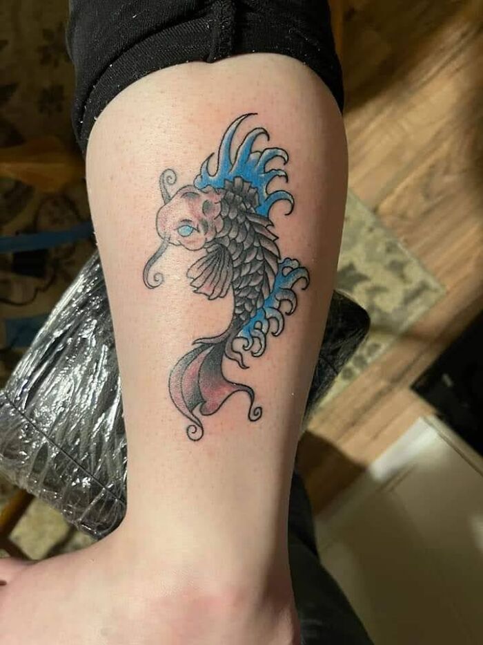 Colorful koi fish tattoo design on a person's arm.