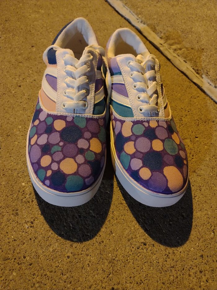 Colorful polka-dot patterned shoes on a concrete surface, showcasing a unique footwear style.