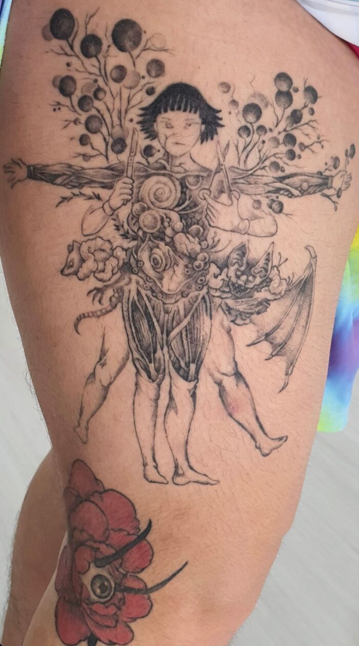 Coolest looking tattoo depicting a surreal figure with multiple limbs and floral elements on a person's leg.
