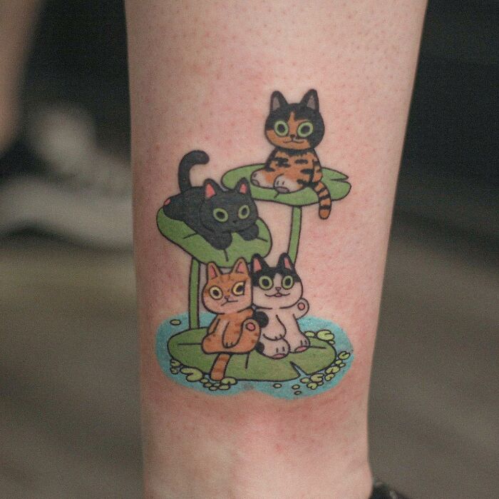 Adorable animal-themed tattoo of colorful cats sitting on lily pads.