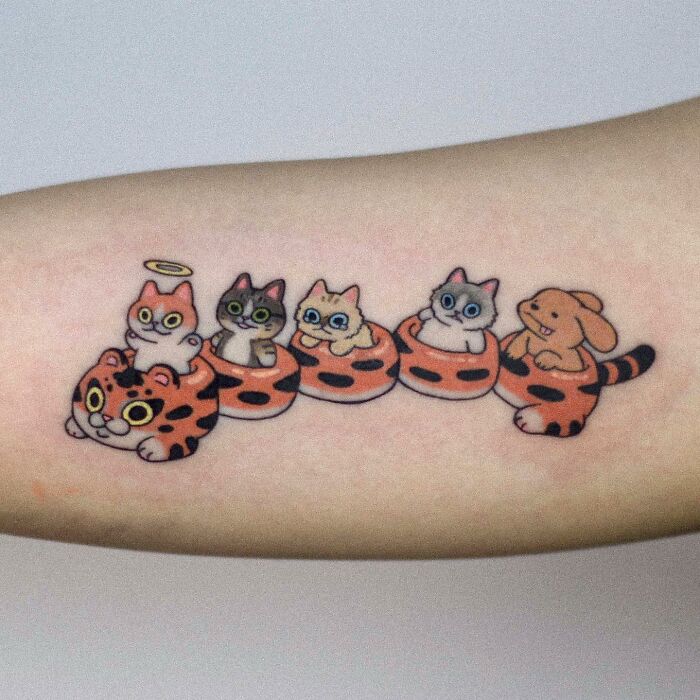 Adorable animal-themed tattoo featuring cute cats and a bunny on a person's arm.