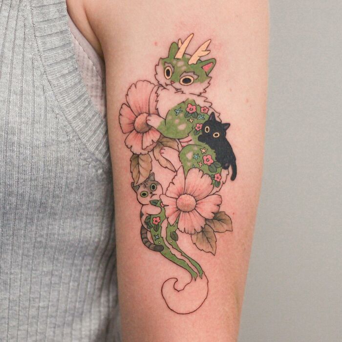 Tattoo artist's adorable animal-themed design on arm, featuring colorful creatures and flowers.