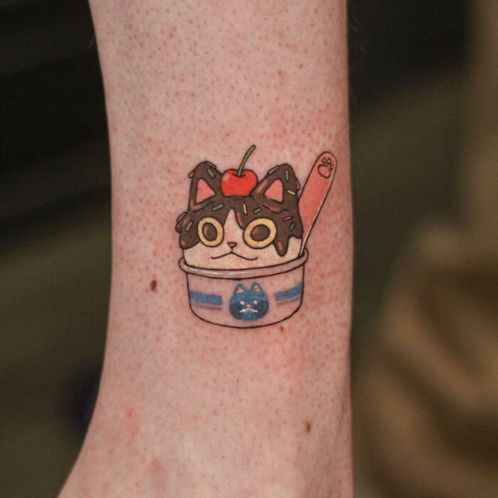 Adorable animal-themed tattoo of a cat sundae with sprinkles and a cherry on top.