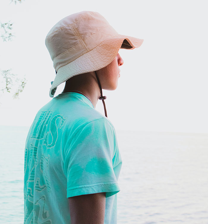 Man in blue crew neck shirt wearing brown hat