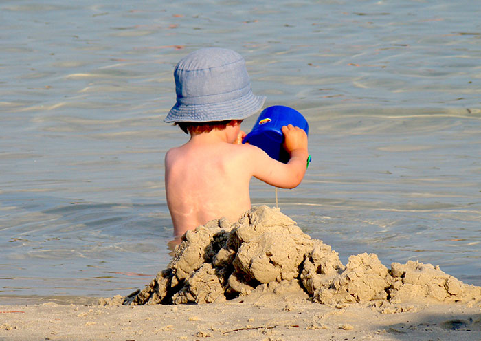 Kid playing with sand at the beach