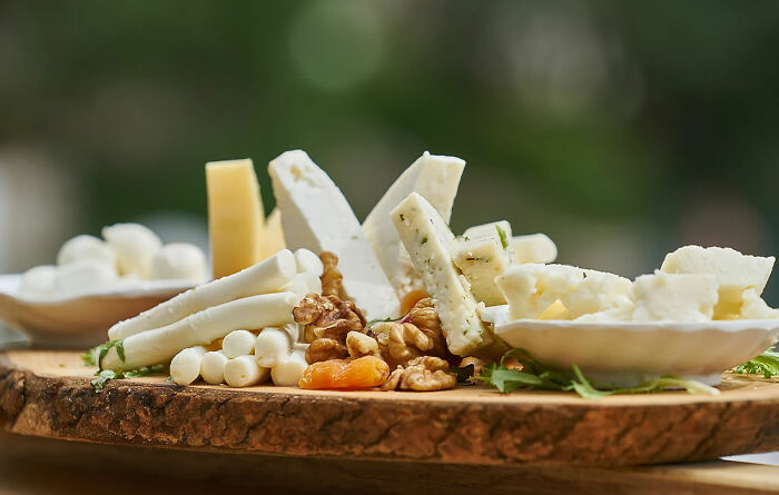 different kinds of cheese with walnuts on a wooden board